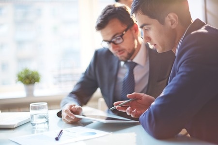 47055784 - young businessmen discussing data at meeting